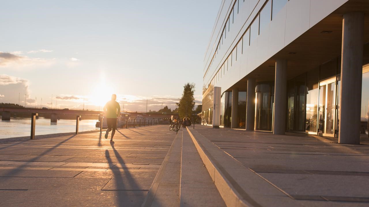 Silhuette av en person som springer mot solen. Platsen &auml;r bredvid V&auml;ven i Ume&aring;.