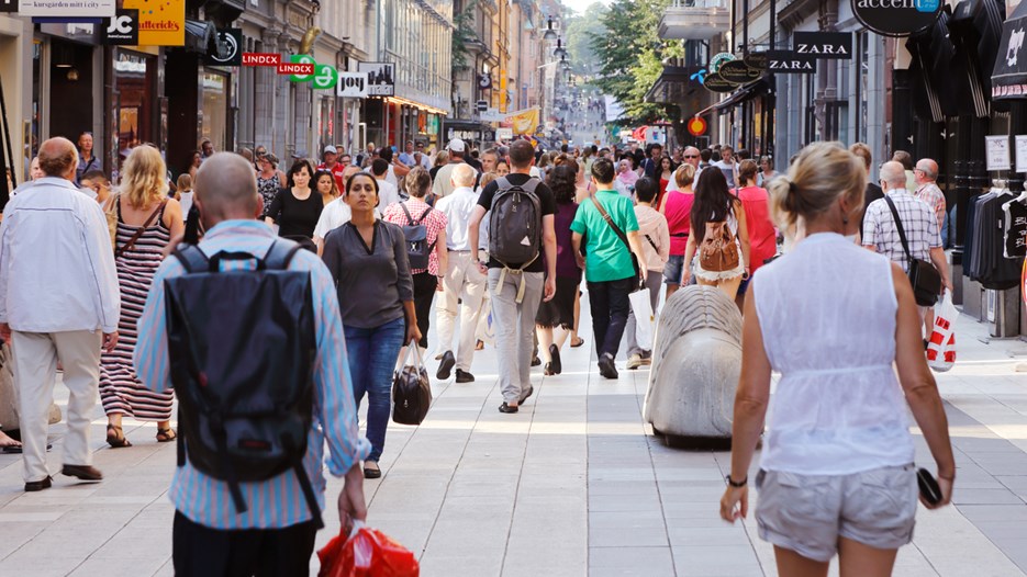 Sommardag på gågatan Drottninggatan mellan Mäster Samuelsgatan och Kungsgatan i Stockholm, Sverige, med folk i rörelse.