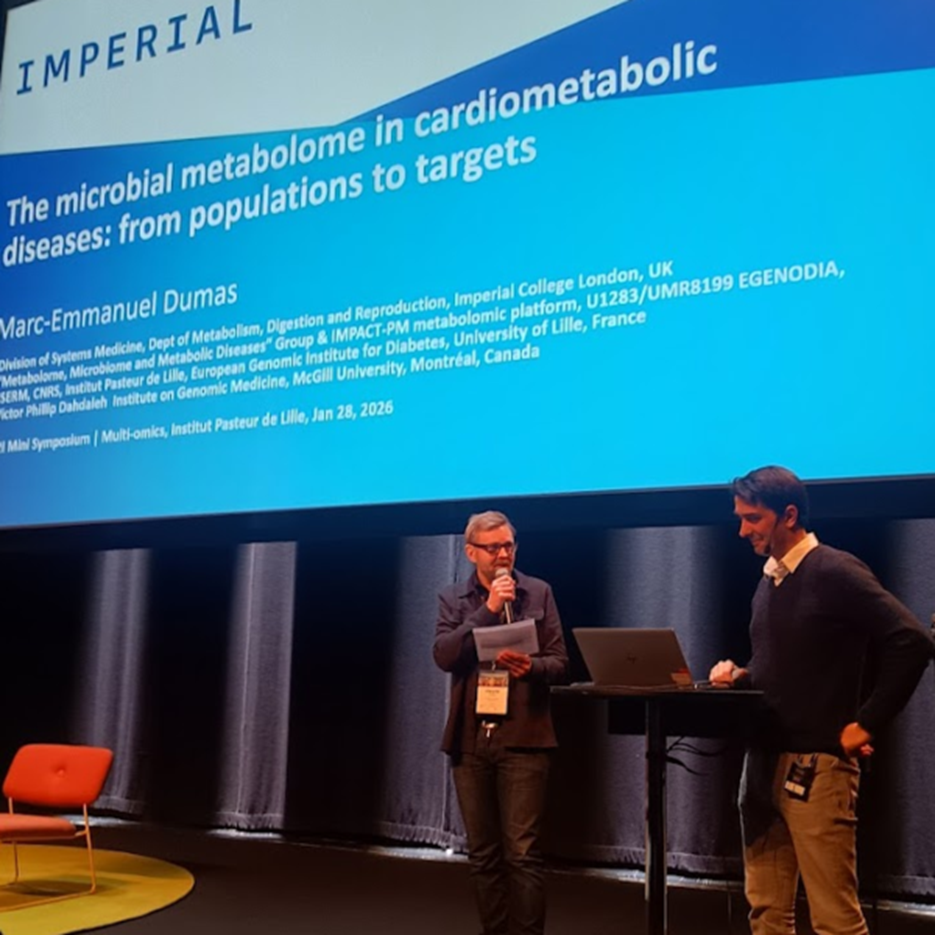 Two persons standing on stage at the scientific conference