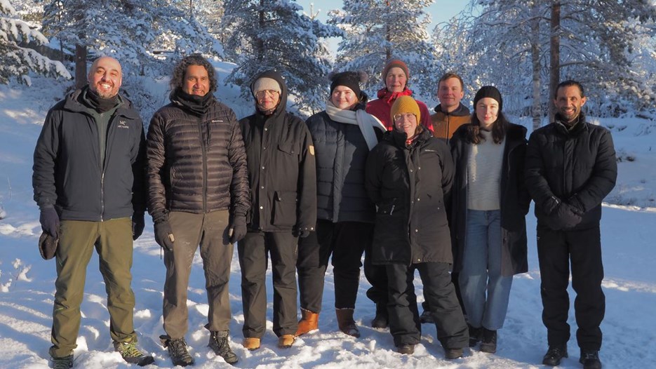 Group of people standing in the snow with a background of winter landscape