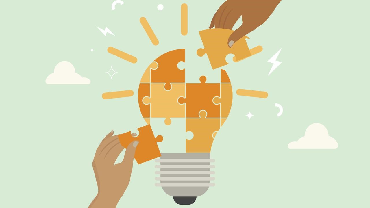 Light bulb made up of bits of a jig saw puzzle with hand gripping at pieces.