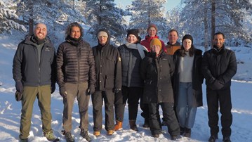 Group of people standing in the snow with a background of winter landscape
