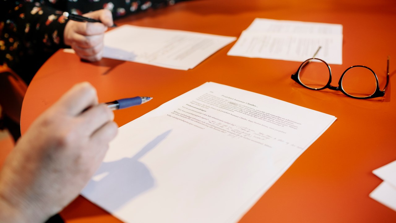 Händer som håller papper.