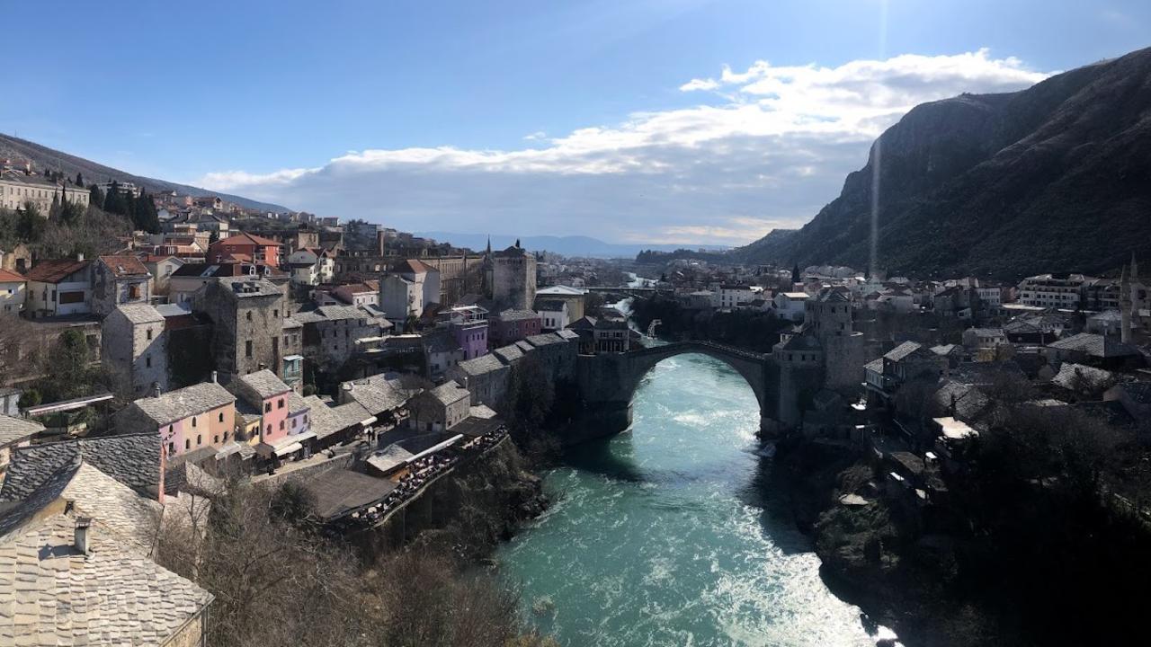 En flod som rinner genom en stad intill ett berg.