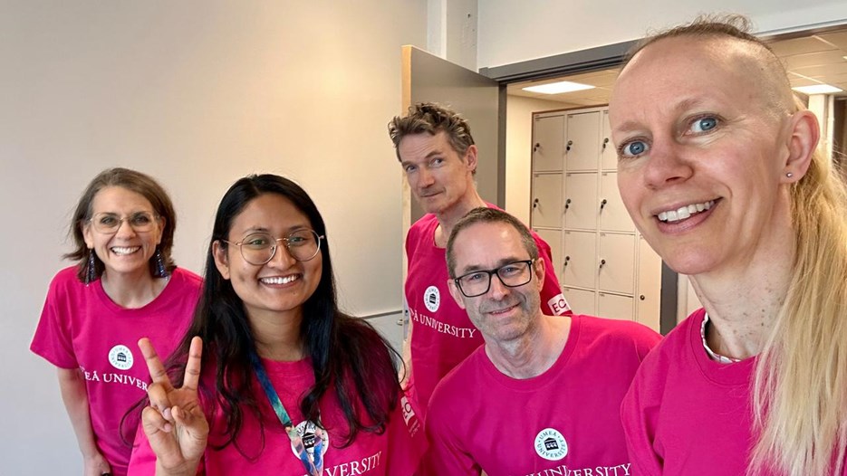 En grupp människor i rosa skjortor som poserar för en bild.