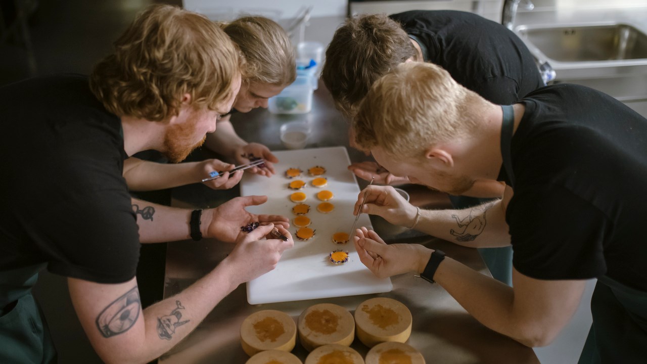 Studenter vid gastronomiprogrammet förbereder måltid i köksmiljö