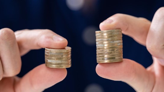Two hands holding a stack of coins each.