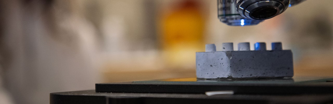 En legobit i cement under ett mikroskop