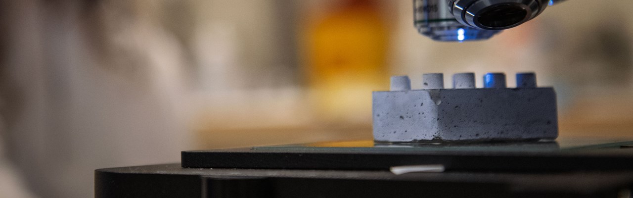 En legobit i cement under ett mikroskop