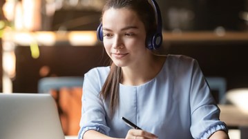 Kvinna som sitter i framför datorn i ett digitalt möte.