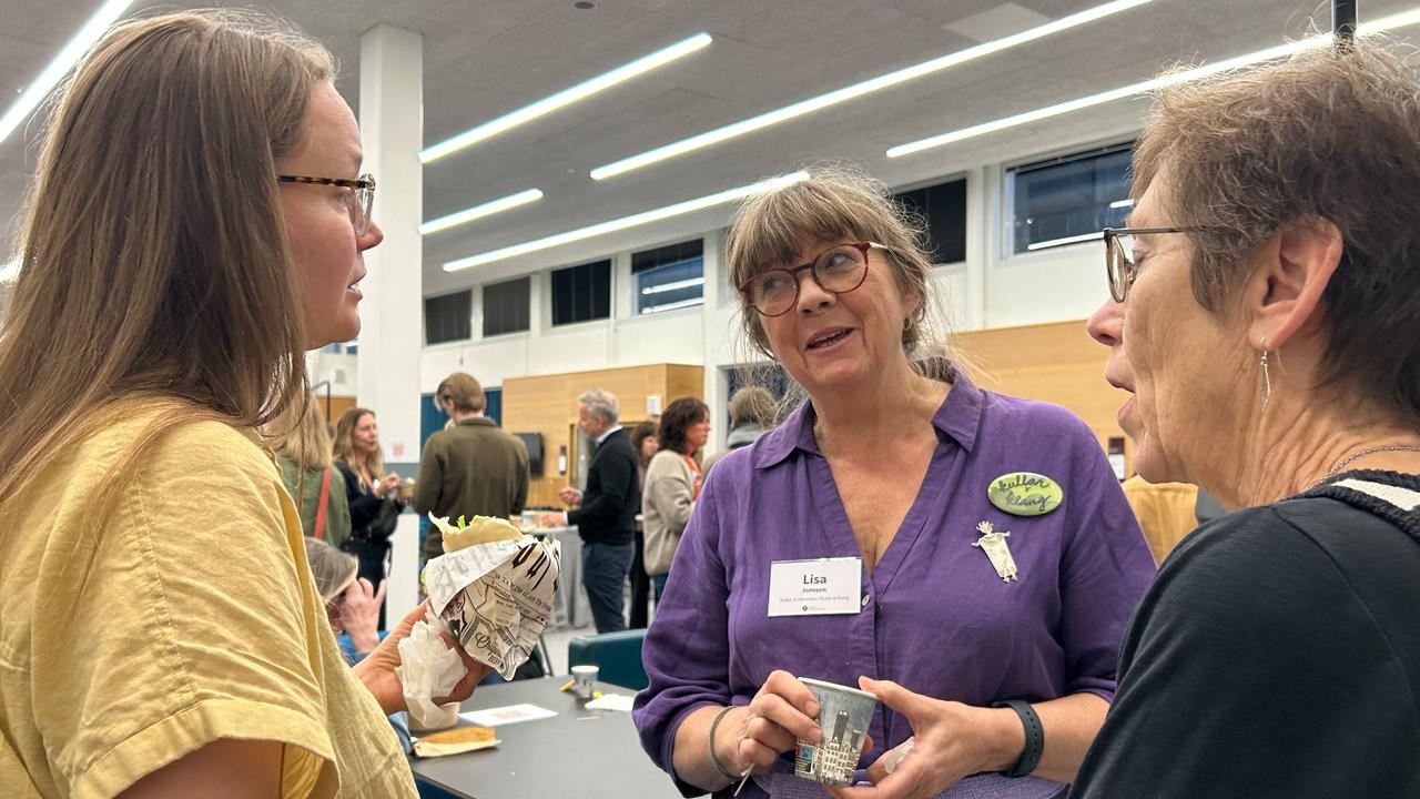 En grupp kvinnor som pratar med varandra i ett rum.