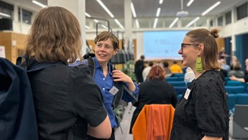 En grupp människor som pratar i en konferenslokal.