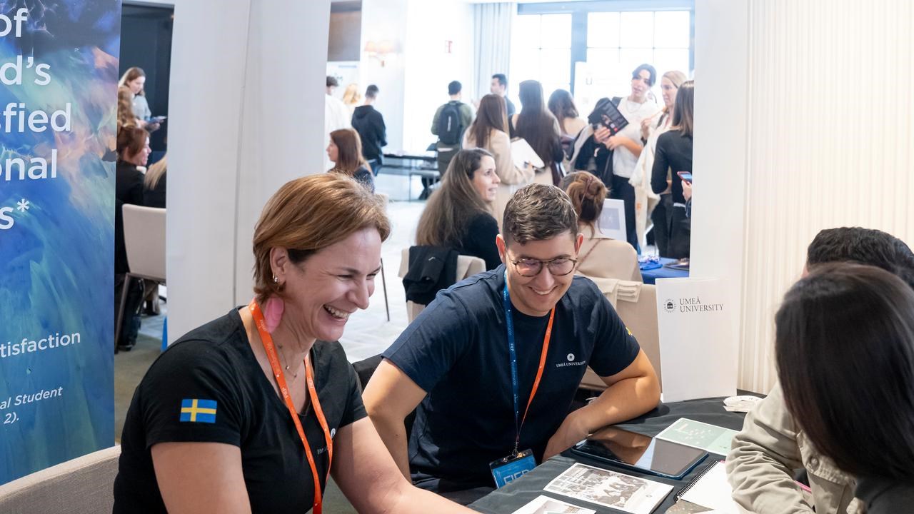 Representatives from Umeå University in a student fair, talking to prospective students.
