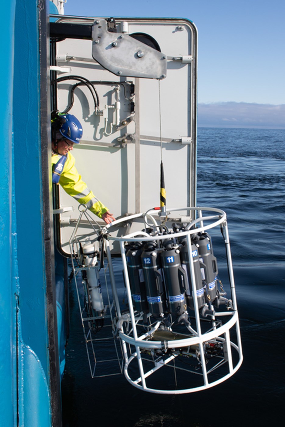 A person taking water samples from a ship.