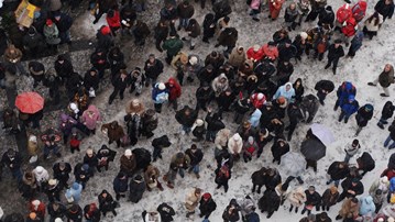 En stor grupp människor som står i snön.