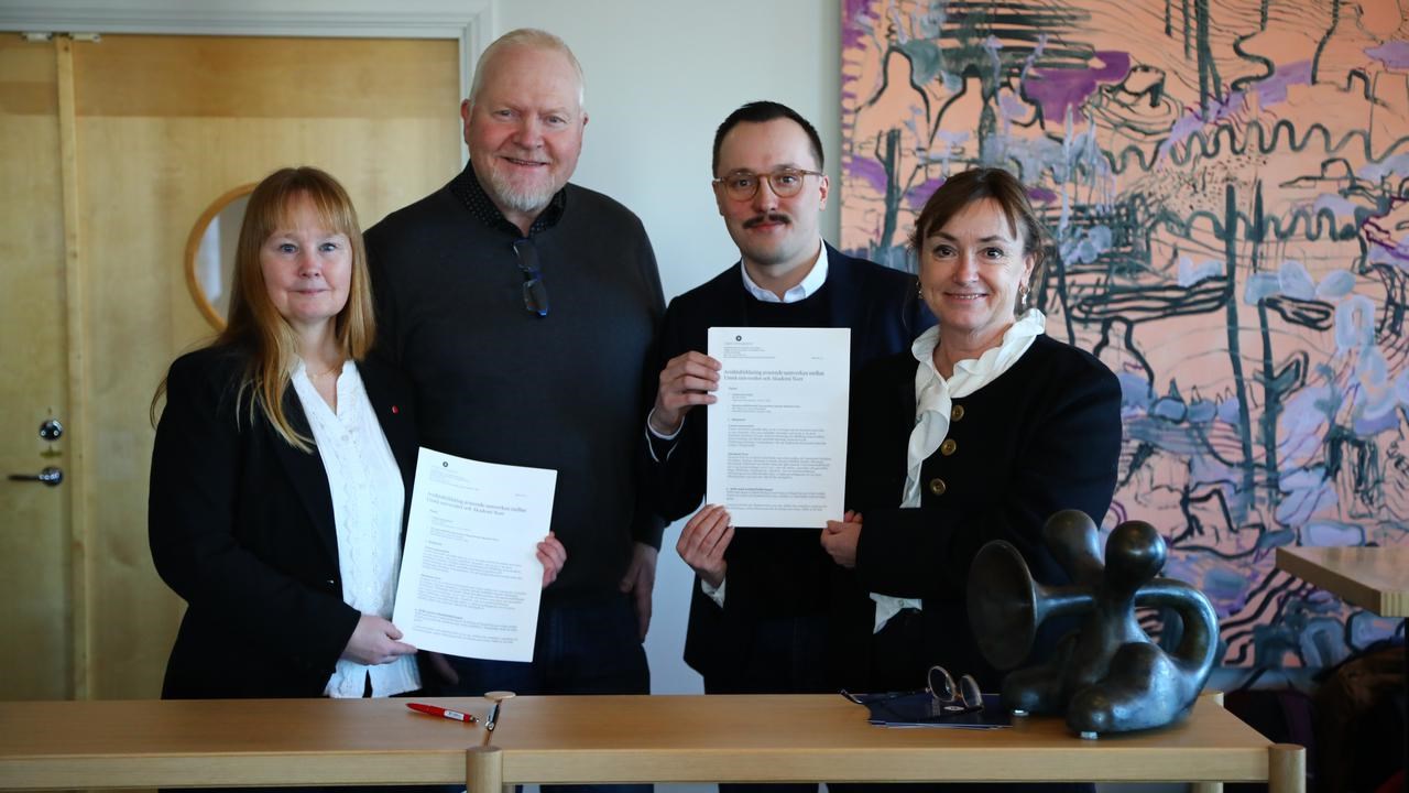 En grupp m&auml;nniskor som st&aring;r bredvid varandra och h&aring;ller i papper.