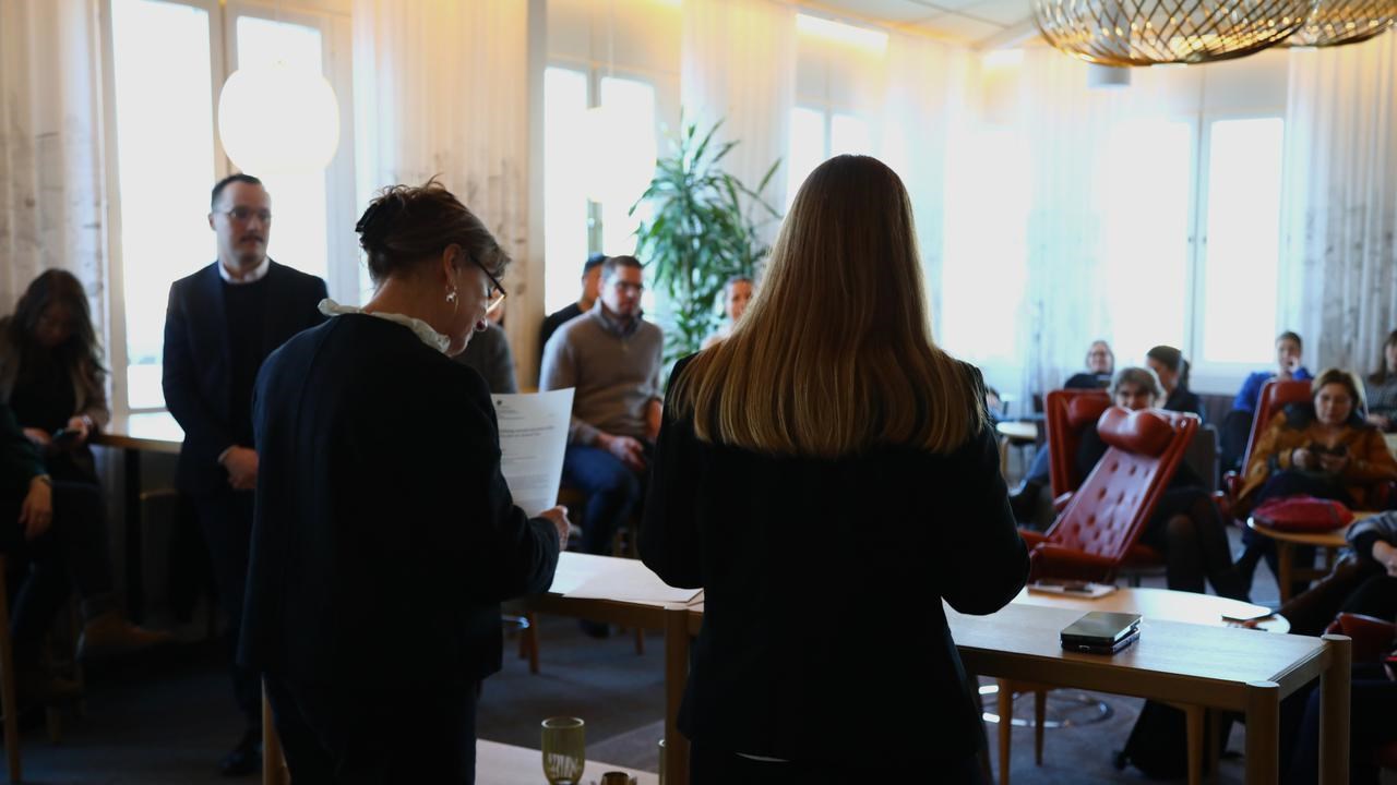 En grupp m&auml;nniskor som st&aring;r i ett rum.