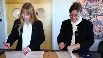 Några kvinnor som står bredvid varandra vid ett skrivbord.