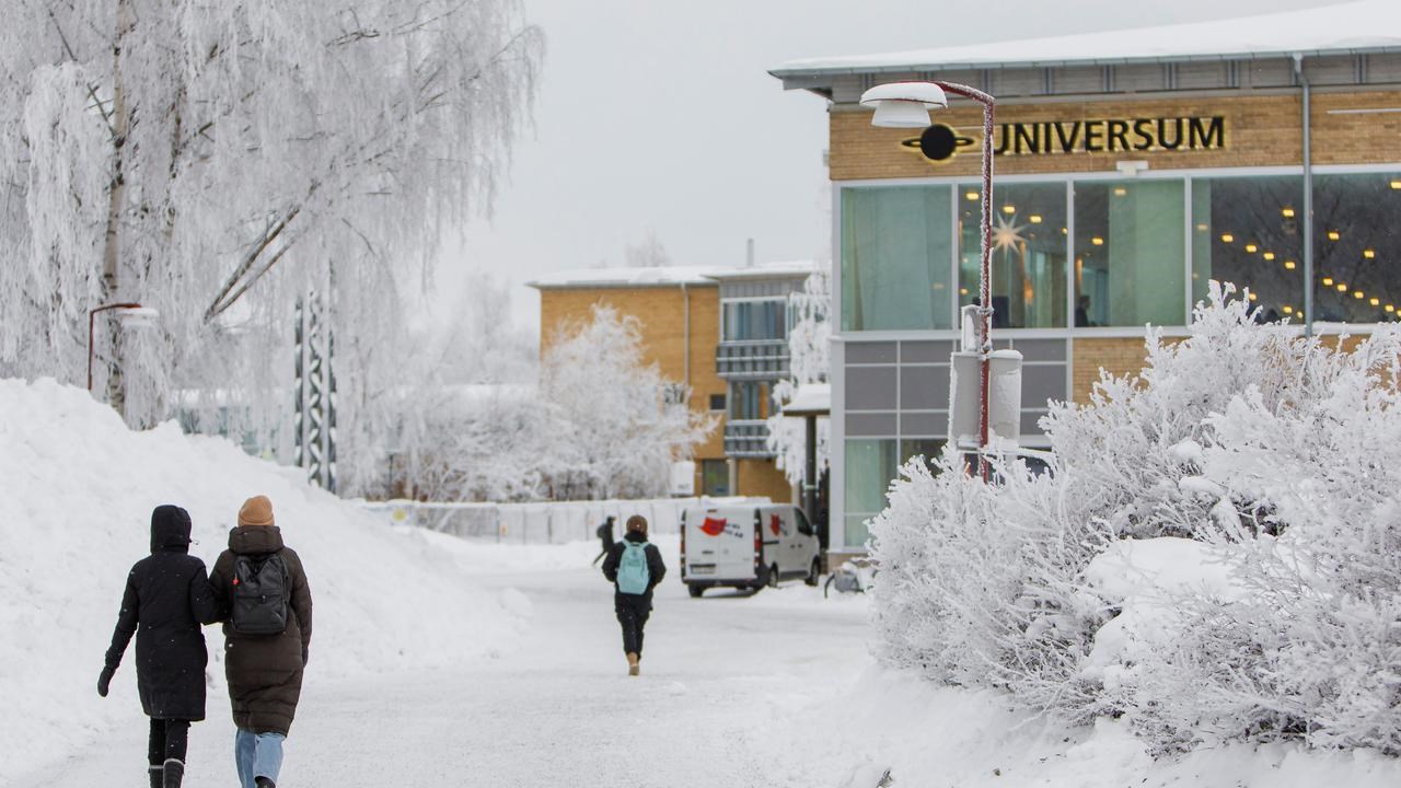 Studenter promenerar mot Universum-byggnaden på ett vintrigt campus.