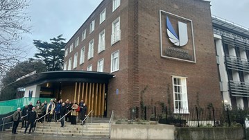 En grupp människor som står framför en byggnad.