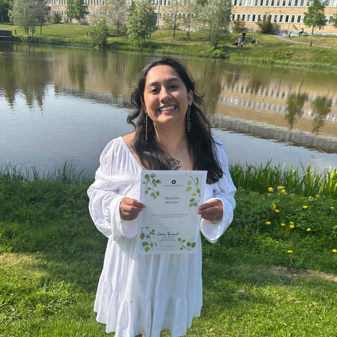 New graduate by the campus pond at Umeå University