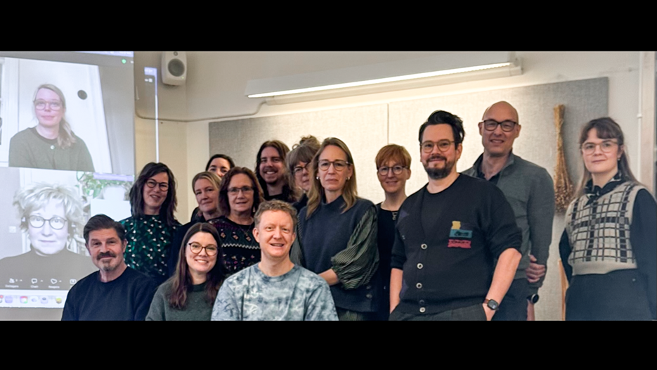 En grupp människor som står framför en projektorduk.