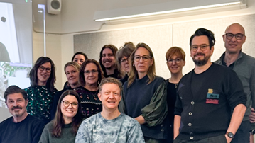 En grupp människor som står framför en projektorduk.