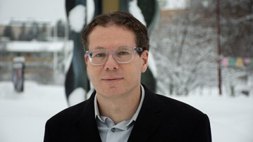 Christian Ewald, professor, stående framför fontänen utanför MIT-huset på Umeå universitet.