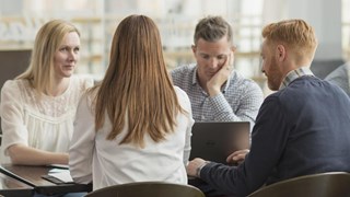 En grupp människor som sitter runt ett bord