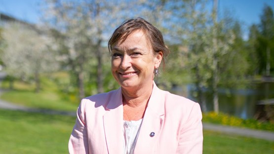 Portrait of a woman in a suit jacket in the campus park.