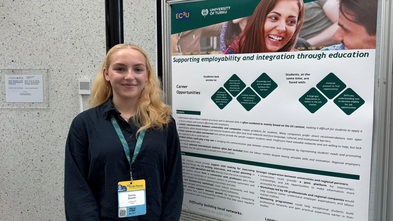 A woman standing in front of a poster.