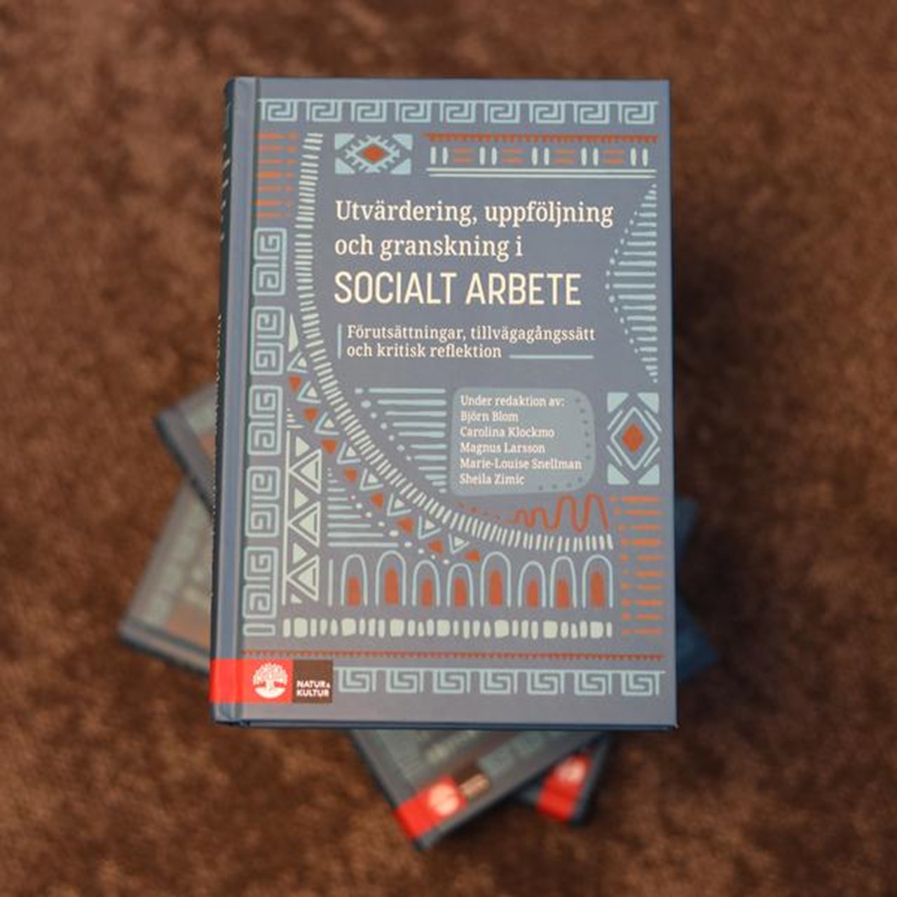 En bok som ligger p&aring; en brun matta.