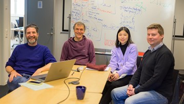 Olivier Keech, Sebastian Diehl, Yun-Ting Jang and Jonas Westin sit at a conference table and smile at the camera. Behind them is a whiteboard with project plans sketched out.