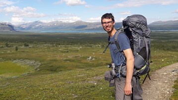 Adrien Heymans, 'EC' postdoktor i öppet landskap med berg i bakgrunden