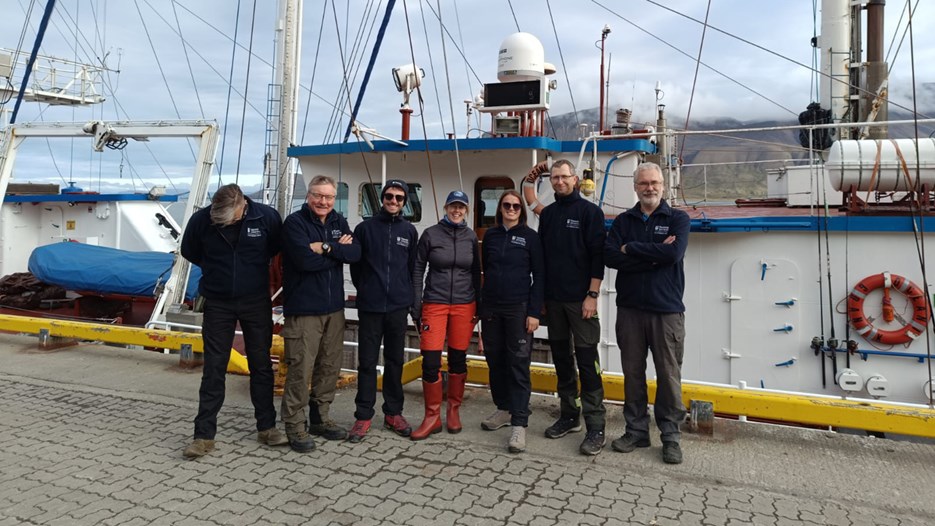 Gruppbild på forskarteam framför en båt på väg till Eidembukta, Svalbard.