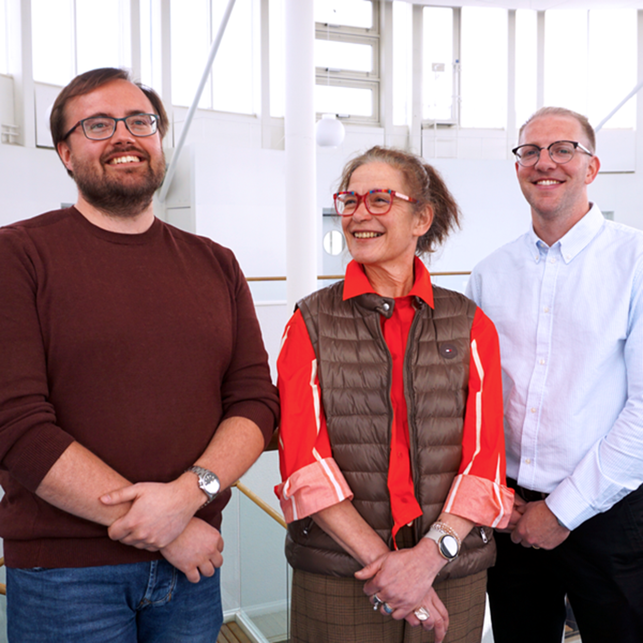 En grupp om tre personer som st&aring;r bredvid varandra.