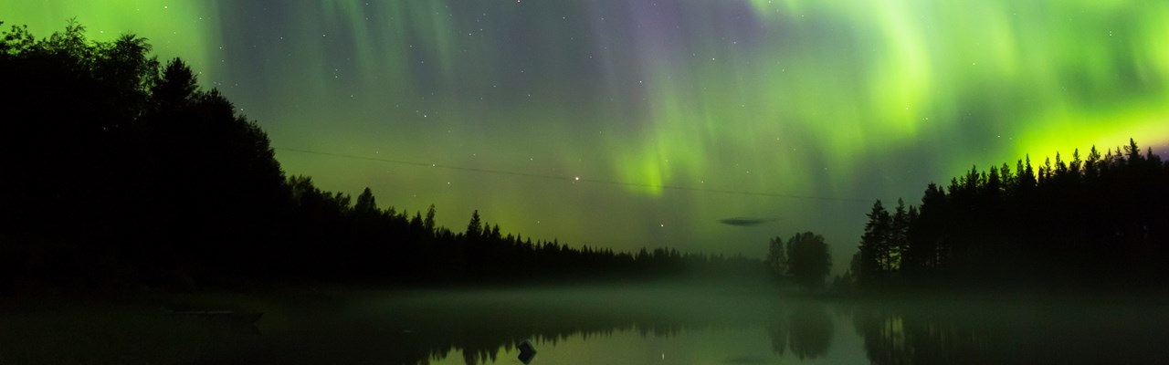 Norrsken som speglas i älven.
