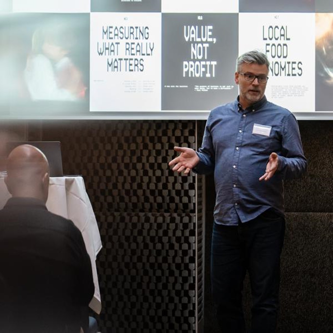 En man st&aring;r framf&ouml;r en projektorsk&auml;rm.