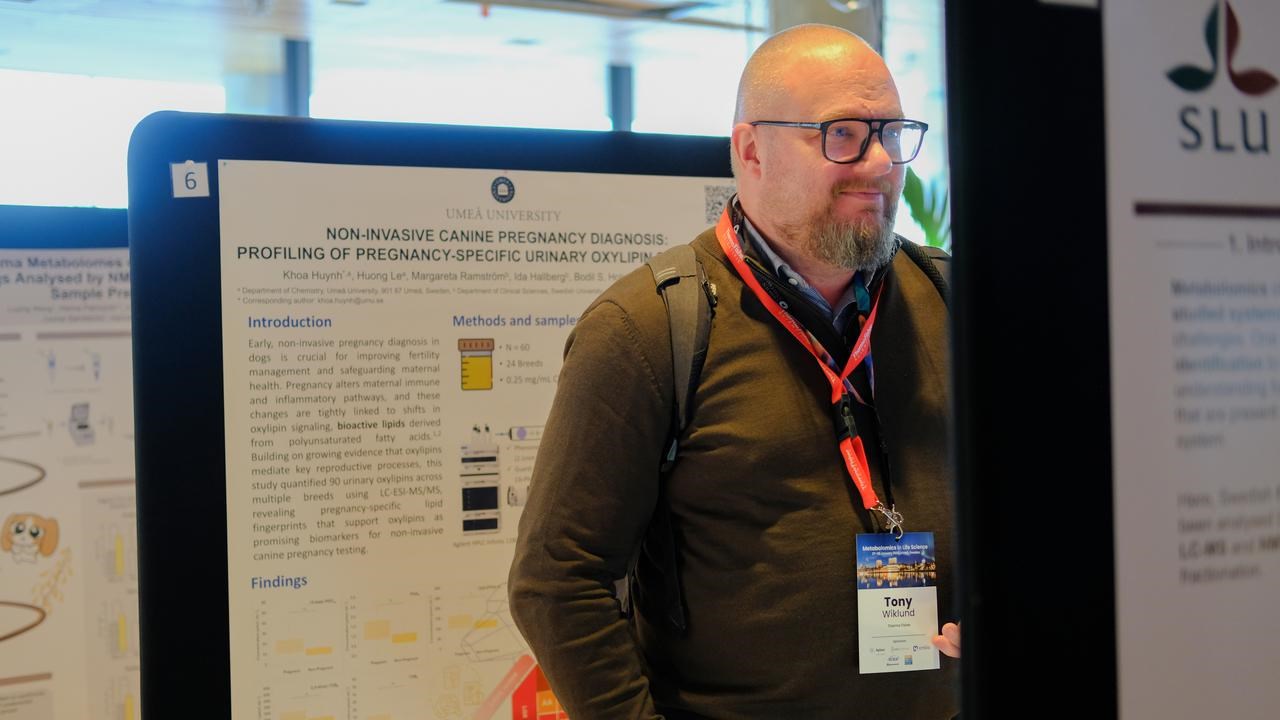 A man standing in front of a poster.