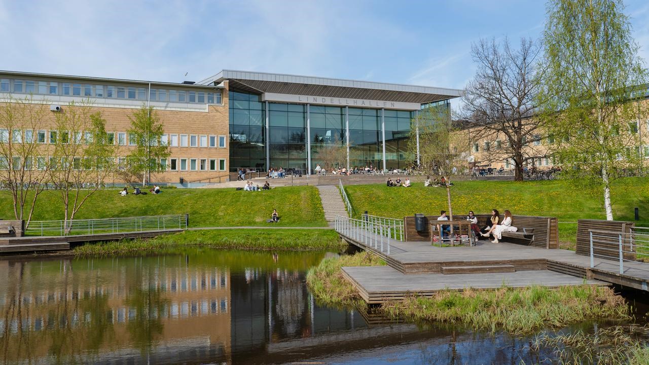 Image of campus pond and students sitting on benches