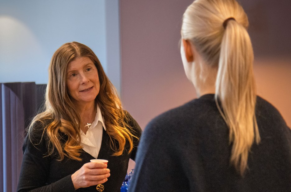 En kvinna som står bredvid en annan kvinna i ett rum.