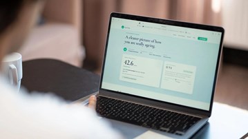 A laptop on a table, on the screen is a calculation of the user's ageing.