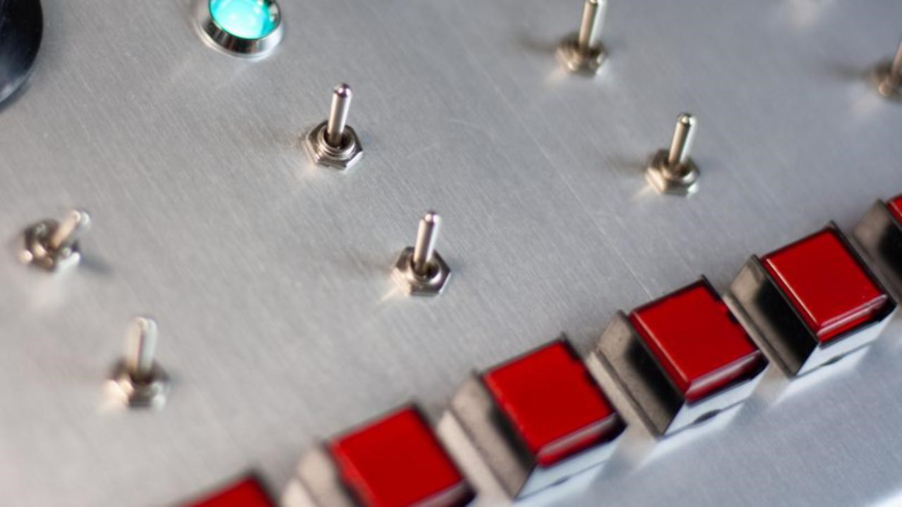 A close up of a control panel with buttons and knobs.