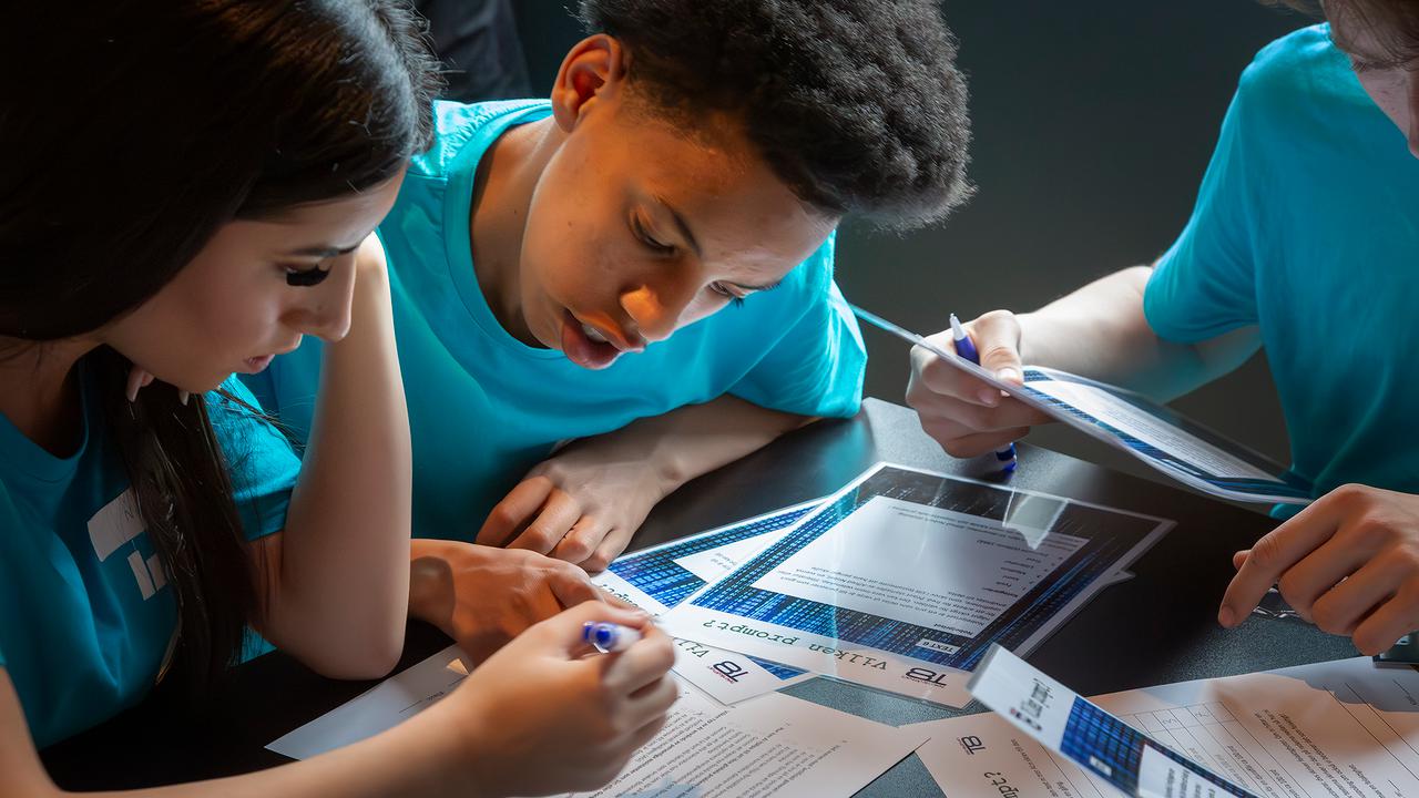 Bild p&aring; tre elever lutade &ouml;ver t&auml;vlingsuppgifter i Teknik&aring;ttans riksfinal