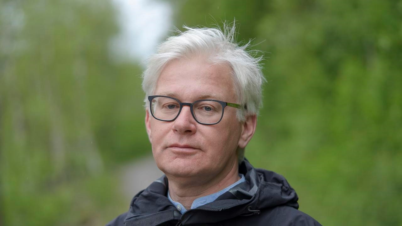En man med glas&ouml;gon som st&aring;r p&aring; en grusv&auml;g.