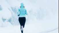 En löpare som springer i ett snöigt landskap.