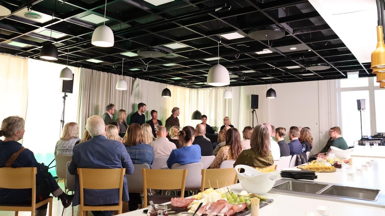 En grupp m&auml;nniskor som sitter runt ett bord i ett rum.