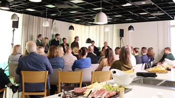 En grupp människor som sitter runt ett bord i ett rum.