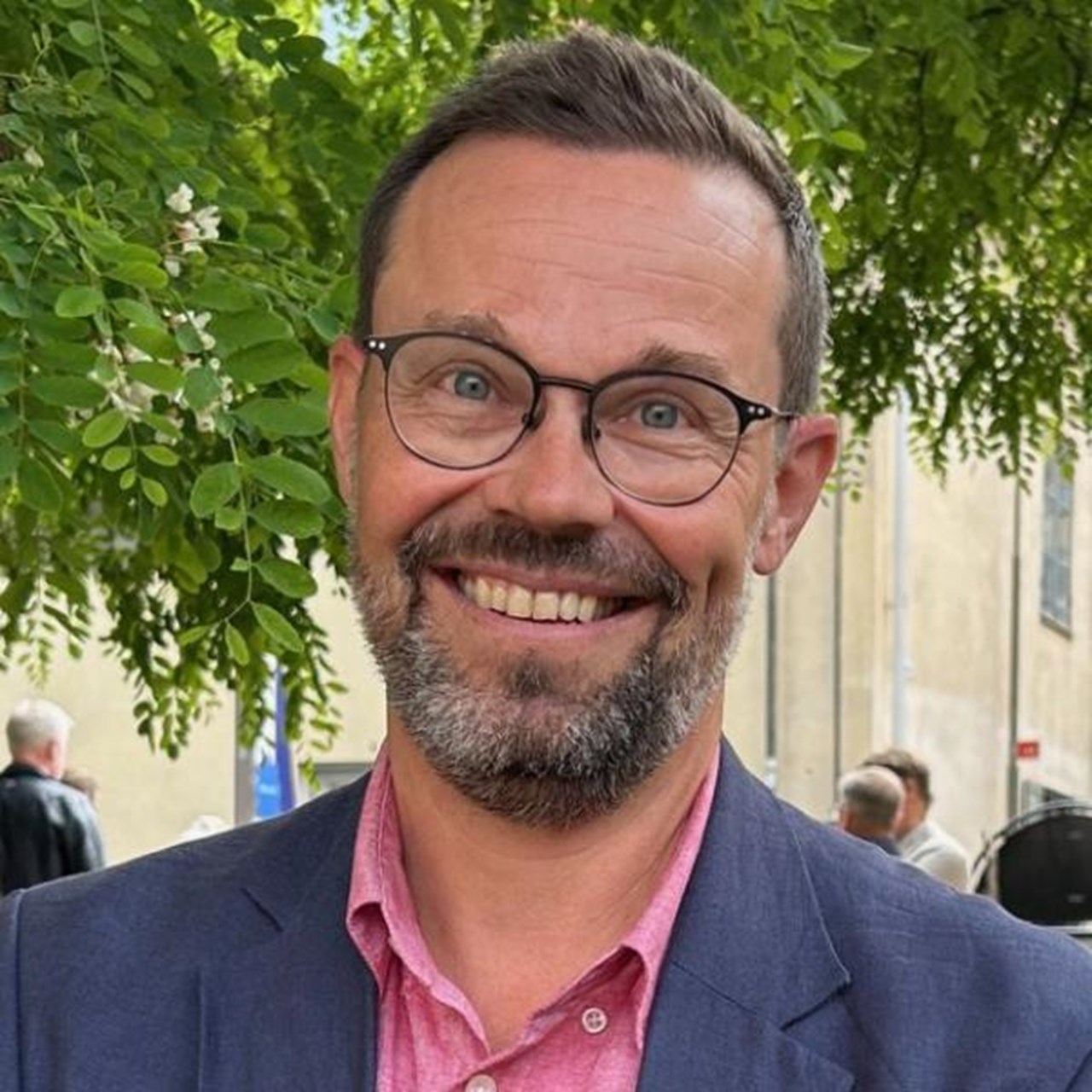 Man i kavaj framf&ouml;r tr&auml;d. I Almedalen p&aring; Gotland.