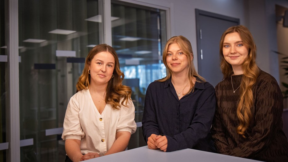 En grupp med tre studenter som sitter bredvid varandra.